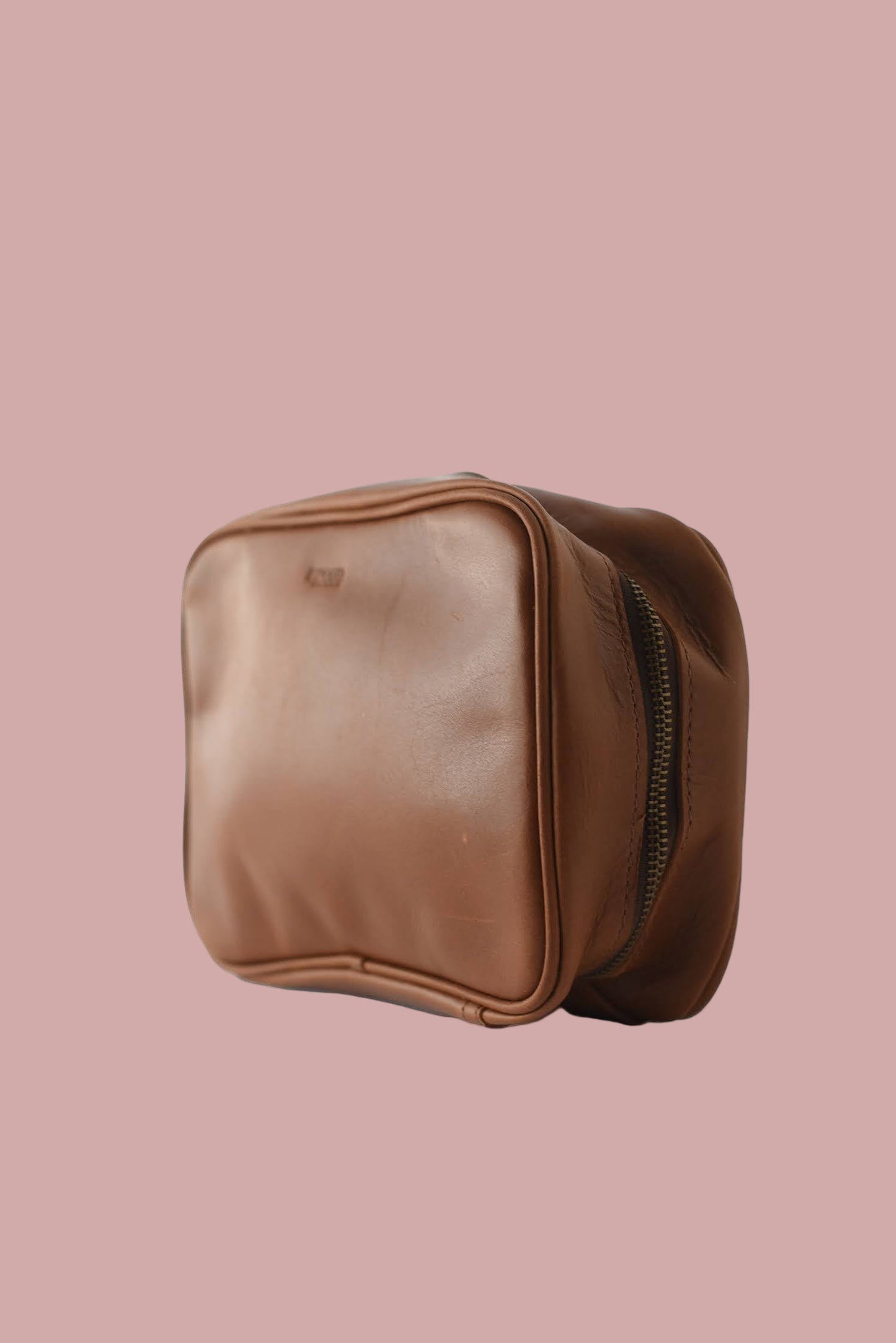 Brown leather pouch with zipper on a white background
