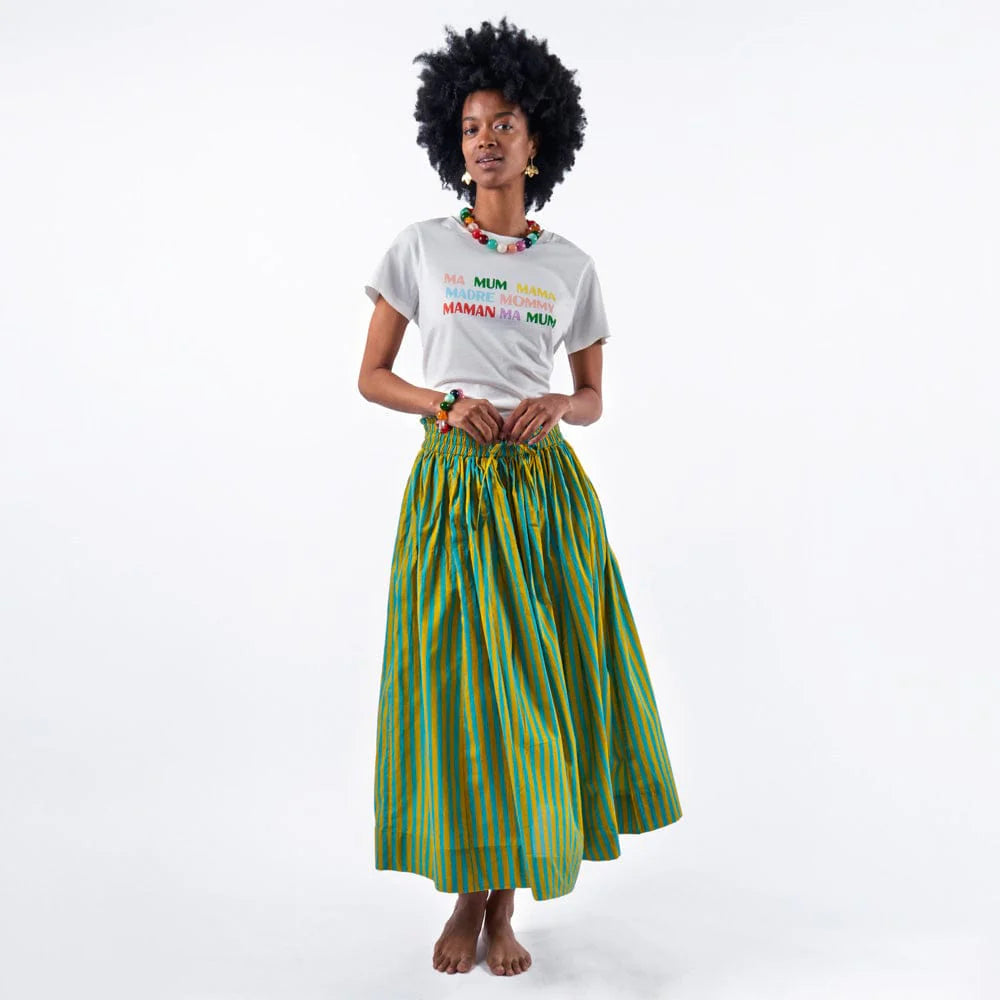 Woman wearing a white t-shirt with colorful text and a green striped skirt on a white background