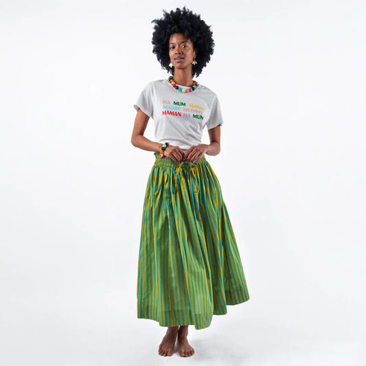 Woman wearing a white t-shirt with colorful text and a green striped skirt on a white background